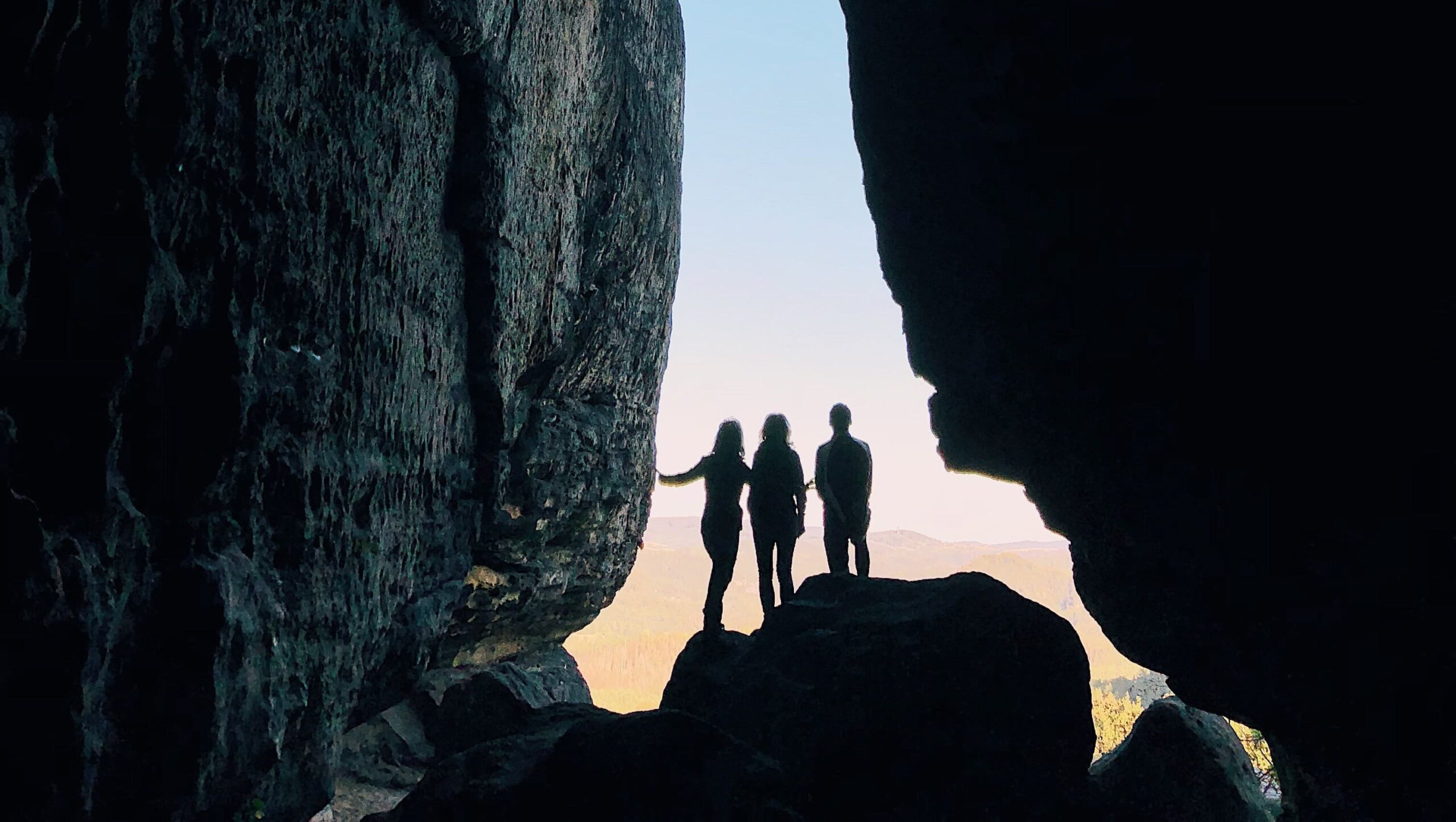 people silhouette rocky escarpment